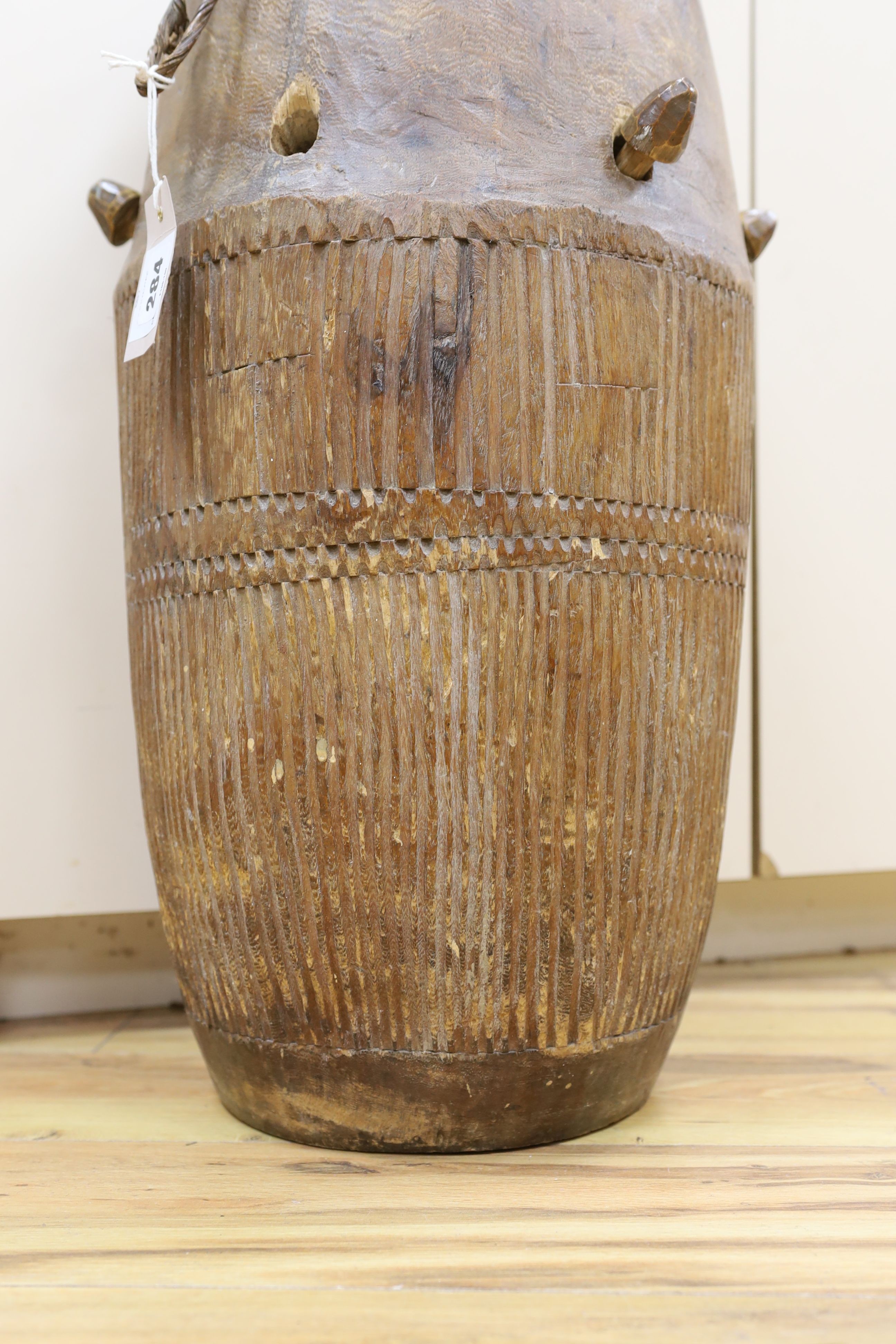 A 19th/20th century Ashanti breasted drum, 61 cms high.